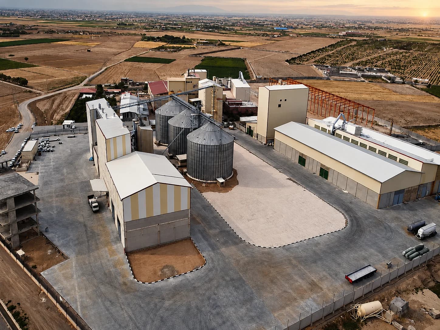 Aerial view of the plant with mill building, silos, warehouses and surrounding fields